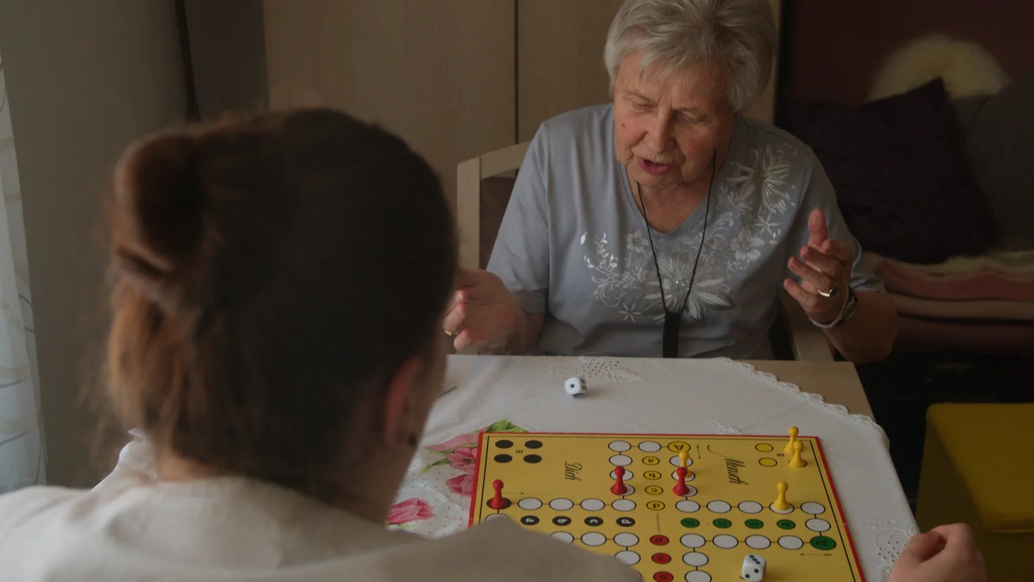 Rentnerin und Pflegerin spielen Mensch Ärgere dich nicht